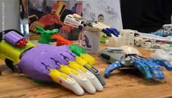 Photo: Several hand devices of e-NABLE on a table at REHACARE 2017; Copyright: beta-web/Anne Hofmann
