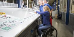 Photo: Wheelchair user in a production hall at a drawing table; Copyright: O4 Wheelchairs GmbH