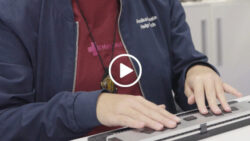 A person's hands on a Braille keyboard; linked to the video