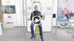 Exhibitor demonstrates a Handi-Move ceiling lift at REHACARE; link to a video