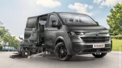 VW New Caravelle Extended with open sliding door and a power wheelchair at the side entrance.