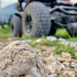 Photo: In the foreground a larger stone can be seen, in the background the X8 power wheelchair is slightly out of focus; Copyright: Sunrise Medical