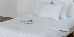 Photo: Bed with a white weighted blanket, on top is a magazine; Copyright: Ribcap