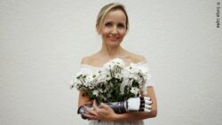 Wioletta Wyrwol holding a bouquet of flowers and wearing a visible forearm prosthesis